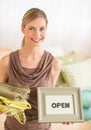 Female Owner Holding Sheets And Open Sign In Bedding Store Royalty Free Stock Photo