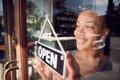 Female Owner Of Start Up Coffee Shop Or Restaurant Turning Round Open Sign On Door Royalty Free Stock Photo