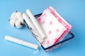 Female pads and tampons on blue paper background