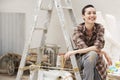 Female Painter Sitting On Ladder At Work Site Royalty Free Stock Photo