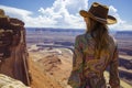 female in paisley dress and stetson looking out over canyon