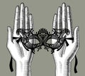 Female palms of hands with a decorative carnival Venetian mask