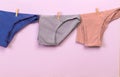 Female panties hanging on rope on pastel background - Image  - Image Royalty Free Stock Photo