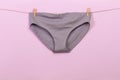 Female panties hanging on rope on pastel background - Image  - Image Royalty Free Stock Photo