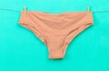 Female panties hanging on rope on pastel background - Image  - Image Royalty Free Stock Photo