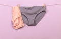 Female panties hanging on rope on pastel background - Image  - Image Royalty Free Stock Photo