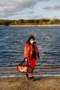 Female paramedic turns around near blue lake and walks to camera