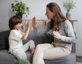 Female parent playing with male kid clapping hands at home. Happy woman spending time with son