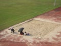 Female parents play with their young children in the sand pit of the sports center