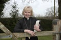 Female parish priest on a house call entering the garden gate