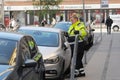 Female parking inspector writing parking fine ticket to auto Royalty Free Stock Photo