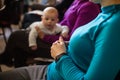 Female participants listening to lecture. Mother with baby at workshop.