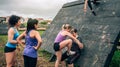 Female participants in obstacle course climbing pyramid obstacle