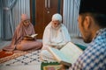 female participants reciting the Quran following the male recitation leader