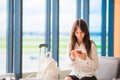 Female passenger in an airport lounge waiting for flight aircraft. Silhouette of woman with cellphone in airport go to Royalty Free Stock Photo