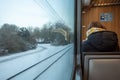 Female passenger with face protection mask who sit in light rail tram in Germany in winter season.