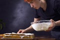 A female pastry chef decorates cake shortcakes with white cream from a glass bowl with a spatula Royalty Free Stock Photo