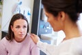 Female Patient Being Reassured By Doctor In Hospital Room