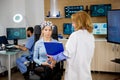 Female patient with brain waves scanning device looking at a clipboard