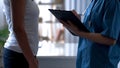 Female patient complaining of bloat, young doctor attentively listening