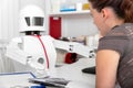 Female patient is consultating a ai medicine robot in his office Royalty Free Stock Photo