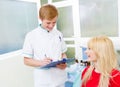 Female patient in dentist office, answering doctor questions Royalty Free Stock Photo