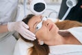 Patient in cosmetology center undergoes a forehead skin rejuvenation procedure Royalty Free Stock Photo