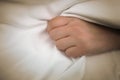 Female patient gripping a fistfull of the bed sheets in one hand Royalty Free Stock Photo