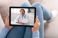 Female patient having video chat with doctor on digital tablet at home Royalty Free Stock Photo