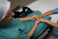 Female patient holding hands of female surgeon at hospital corridor