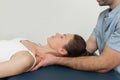 Female patient receiving osteopathic neck and shoulder treatment. Therapist manipulating back of head and chest. A girl Royalty Free Stock Photo