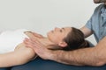 Female patient receiving osteopathic neck and shoulder treatment. Therapist manipulating back of head and chest. A girl Royalty Free Stock Photo