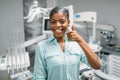 Female patient shows thumbs up in dental clinic