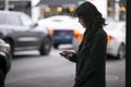 Woman Using a Smartphone App Waiting for a Rideshare