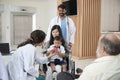 Female pediatric doctor teasing boy for examination at hospital.