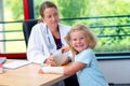 Female pediatrician bandaging the arm of a little girl