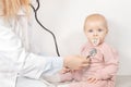 Female pediatrician exam baby girl patient, hold a stethoscope, check heart and lungs of little child. Woman doctor Royalty Free Stock Photo