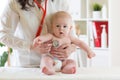 Female pediatrician examining heartbeat of baby with stethoscope Royalty Free Stock Photo