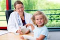 Female pediatrician has candys for a little girl