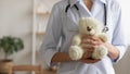 Female pediatrician holding teddy bear in hands, close up view Royalty Free Stock Photo