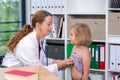 Female pediatrician in white lab coat examined little patient Royalty Free Stock Photo