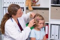 Female pediatrician in white lab coat examined little patient Royalty Free Stock Photo