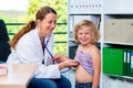 Female pediatrician in white lab coat examined little patient Royalty Free Stock Photo