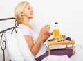 Female pensioner having breakfast in bed Royalty Free Stock Photo