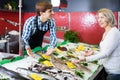 Female pensioner purchasing chilled on ice fish