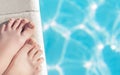 Female with perfect clear pedicure on a pool side. Vacation pericure. Female with bare feet over blue swimming pool Royalty Free Stock Photo