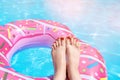 Female with perfect red pedicure over a pool. Vacation pericure. Female with bare feet over blue swimming pool water Royalty Free Stock Photo