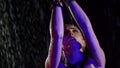 female performer of oriental and arabic dance is dancing alone at night, moving under rain