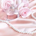 Female perfume bottle, rose, pearls on pink silk Royalty Free Stock Photo