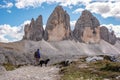 A female person hiking lonely with her dog around the Drei Zinnen mountains, the Dolomites in South Tirol